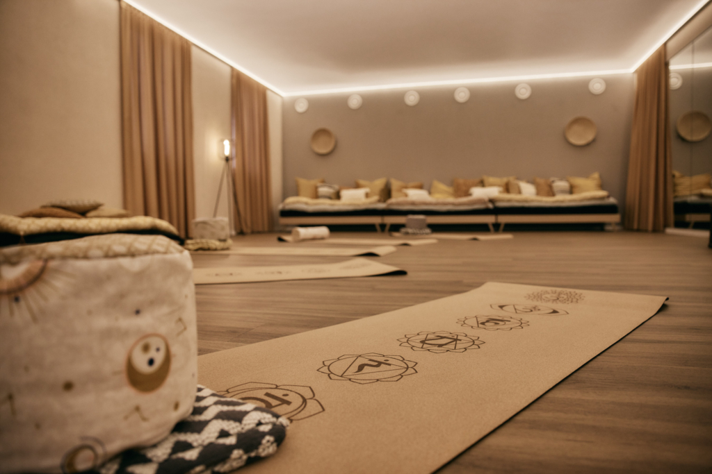 Mehrere ausgerollte Yogamatten mit Equipment, hergerichtet für einen Kurs im Meditationsraum des Hotel Holzapfel