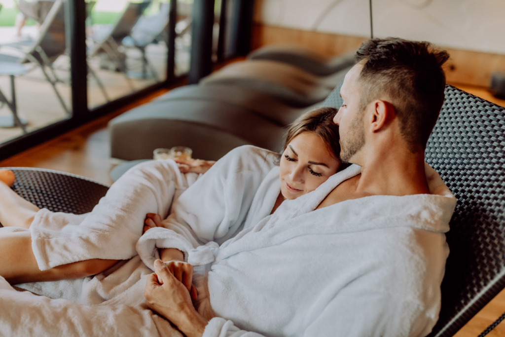 A couple cuddling on a lounger in the spa area of the Ratscher Landhaus